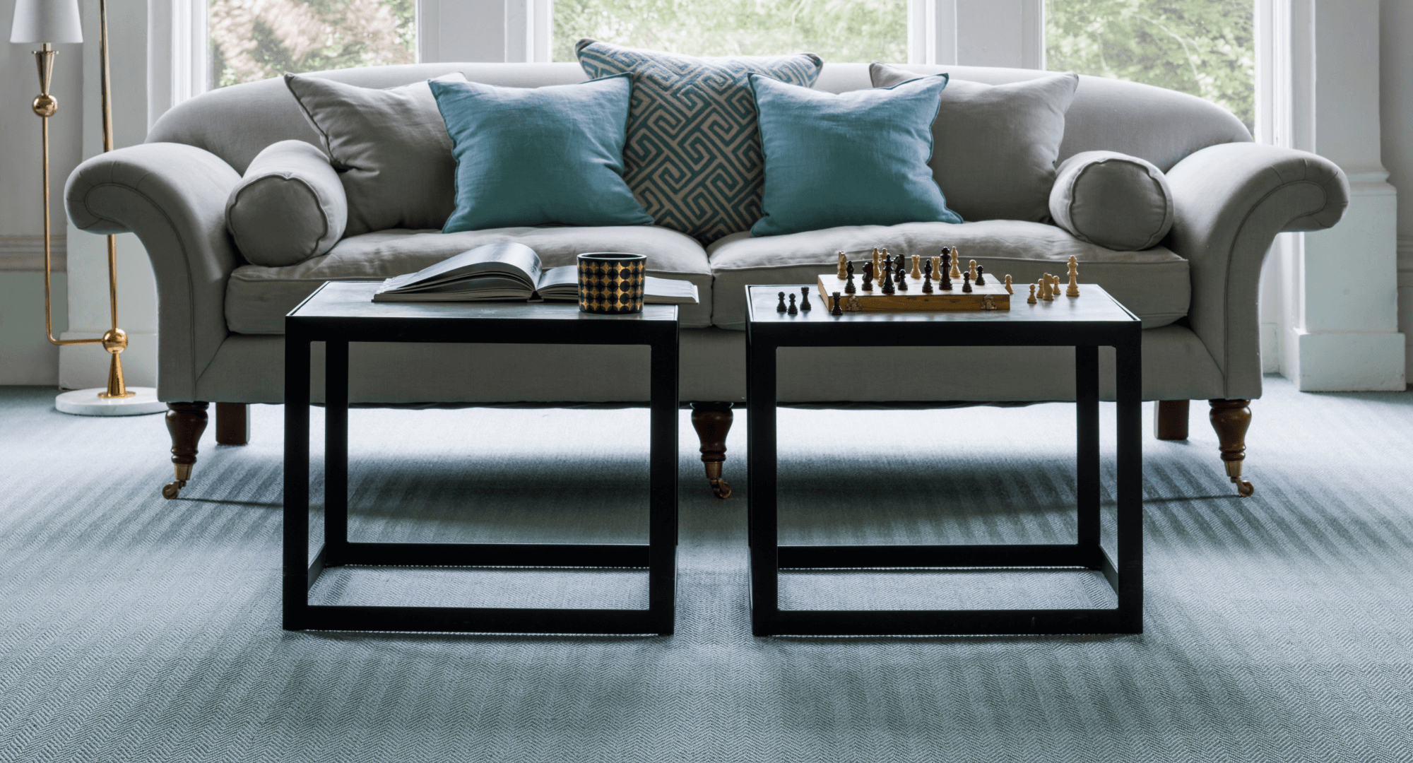 Sofa behind two coffee tables with Crucial Trading carpet on the floor